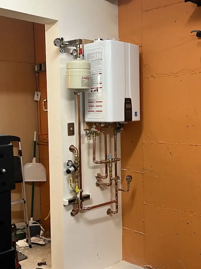 Plumbing technician inspecting water heater connections in Cut Off